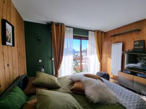 a bedroom with a bed with pillows and a window at STUDIO - ROCHES ROUSSES b in Orcières +21 photos