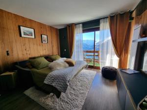 a bedroom with a bed and a large window at STUDIO - ROCHES ROUSSES b in Orcières