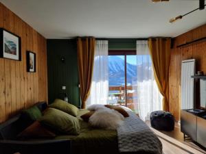 a bed in a room with a large window at STUDIO - ROCHES ROUSSES b in Orcières
