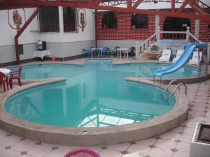 una gran piscina con un tobogán. en CASTILLO DEL VALLE, en Quito