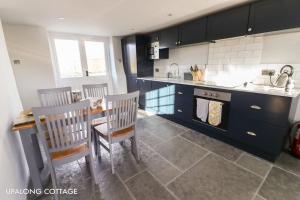 a kitchen with a sink and a table and chairs at UpAlong Cottage - HiddenDevon in Winkleigh