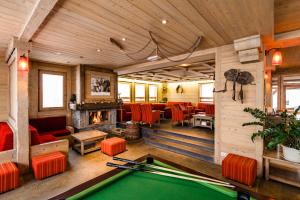 a room with a pool table and a fireplace at Lagrange Vacances Les Hauts de Comborcière in La Toussuire