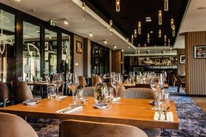 a restaurant with a long wooden table and chairs at Hotel Beskid BALNEO Medical Resort & SPA in Piwniczna