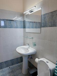 a bathroom with a sink and a toilet and a mirror at Mammis Studios in Kardamaina