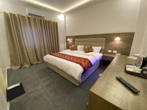 ein Hotelzimmer mit einem Bett und einem Schreibtisch in der Unterkunft Petra Oleander Hotel in Wadi Musa