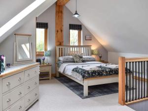 a bedroom with a bed and a dresser at Rowanlea Lodge With Hot Tub in Marykirk