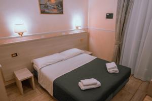 una camera da letto con un letto e due asciugamani di Hotel Aristotele a Roma