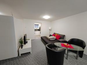 Apartments Merci في أوسترافا: غرفة معيشة مع أريكة وطاولة