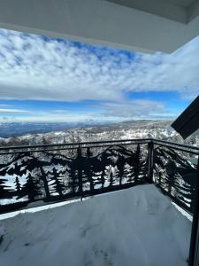 a view from the balcony of a house with snow at GENCIAN RESORT in Kopaonik