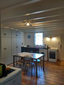 a kitchen with a table and chairs in a room at Gite climatisé L'Orée des Landes Proche Center Parcs in Pindères