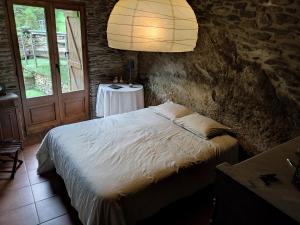 a bedroom with a bed with a lamp and a table at Cobert de Martí in Bayasca