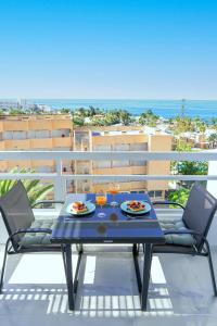 un tavolo con due piatti di cibo su un balcone di SEA LA VIE Ponderosa 617 a Playa Fañabe