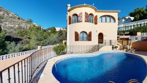 Villa con piscina frente a una casa en Villa Encinas, en Cumbre del Sol