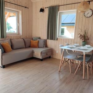 a living room with a couch and a table at Domek z balią in Chmielno +32 photos