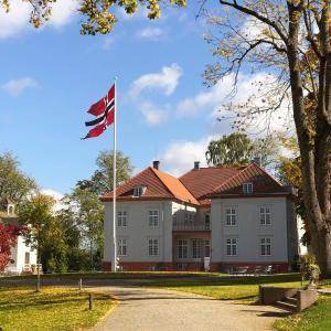 a british flag flying in front of a large building at Two bedroom apartment, top floor, stunning views in Eidsvoll
