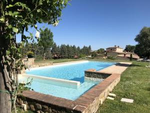 - une piscine dans une cour avec un mur de retenue dans l'établissement Villa Falco, à Trequanda
