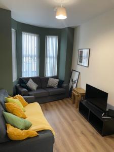 a living room with a couch and a piano at Casement Townhouse in Belfast