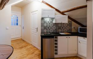 a kitchen with white cabinets and a black counter top at Brasserie de L ouest in Chartres