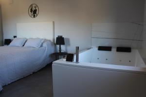 een slaapkamer met een bed en een bad bij CASA RURAL MENSIN in Villar de Canes