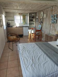 a bedroom with a bed and a kitchen with a table at Les Cigales du Bassin in Gujan-Mestras