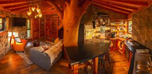 una sala de estar con sofá y mesa en una cabaña en Encantadora Casa del Árbol en el Valle del Elqui! en La Serena