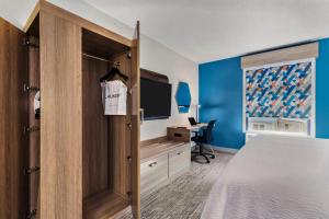 Dormitorio con cama, escritorio y TV en Holiday Inn Express New Albany, an IHG Hotel en New Albany