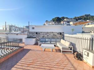 un patio avec deux canapés sur le toit dans l'établissement La Chiocciola, à Capri