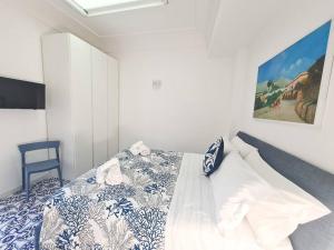 una camera con un letto e un piumone blu e bianco di La Chiocciola a Capri