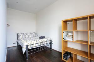 um quarto com uma cama e uma estante de livros em Entire luxurious flat sleeps 4 persons em Londres
