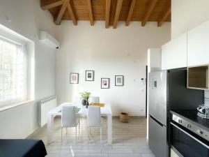 a kitchen with a white table and white chairs at Dimora il Fontanile in Castel di Guido