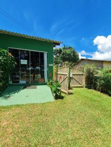 een groen huis met een hek en een tuin bij Hospedagem Alternativa in Alto Paraíso de Goiás