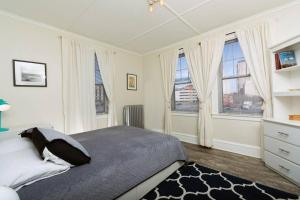 a bedroom with a large bed and two windows at The Elizabeth Suite B2 CURRENT Upgrades Underway Daily! in Hartford
