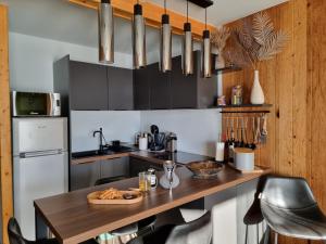 a kitchen with a wooden counter with a table and chairs at STUDIO - ROCHES ROUSSES b in Orcières