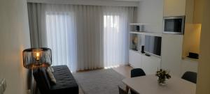 a living room with a couch and a table with a television at Light Brown Central Apartment in Aveiro
