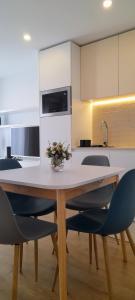 cocina con mesa con sillas y microondas en Light Brown Central Apartment, en Aveiro