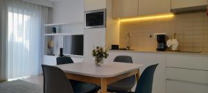 a table with chairs and a vase of flowers on it at Light Brown Central Apartment in Aveiro
