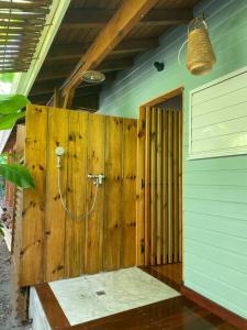 uma parede de madeira com um chuveiro num quarto em Villa Acoma Lodge em Grand-Bourg