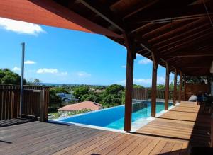 a wooden deck with a swimming pool on top of a house at Villa Acoma Lodge in Grand-Bourg