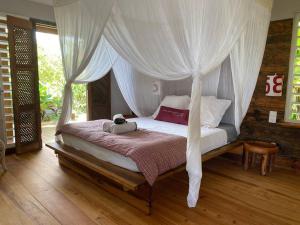 a bedroom with a bed with a canopy at Villa Acoma Lodge in Grand-Bourg