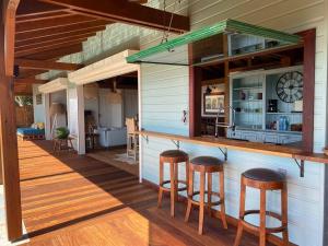 a bar on a deck with stools in a house at Villa Acoma Lodge in Grand-Bourg