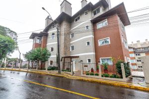 un edificio de apartamentos en una calle lluviosa en Rosa Edifício Villa Rossa, en Gramado