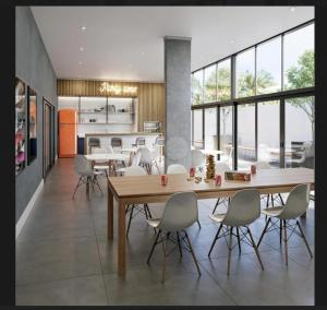 a kitchen and dining room with a wooden table and chairs at Apto Stúdio Área Central - 2 pessoas - Crianças Grátis - Colchão com massageador - Próx do Shopping Estação!! in Curitiba