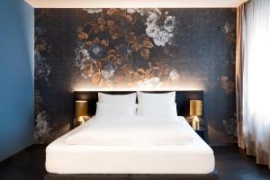 a bedroom with a large white bed with a floral wallpaper at Aiola Living Graz in Graz