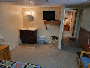 uma sala com um quarto com uma televisão na parede em The Hulett Motel 