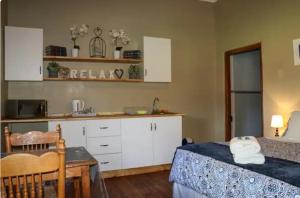 a kitchen with a bed and a table in a room at Vredelus Farm Stay in De Rust