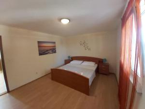 ein kleines Schlafzimmer mit einem Bett und einem Fenster in der Unterkunft Apartments Elvir Nin in Nin
