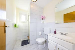 ein weißes Badezimmer mit Toilette und Waschbecken in der Unterkunft Apartments Elvir Nin in Nin + 37 Fotos