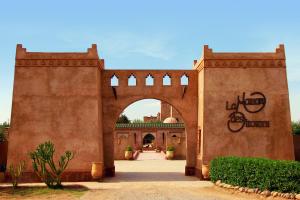 a large stone building with a clock on the side of it at La Maison Des Oliviers in Marrakesh