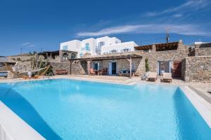 a large swimming pool in front of a villa at Salty View in Mikonos
