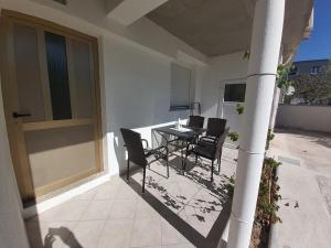 eine Terrasse mit einem Tisch und Stühlen auf einem Haus in der Unterkunft Apartments Elvir Nin in Nin